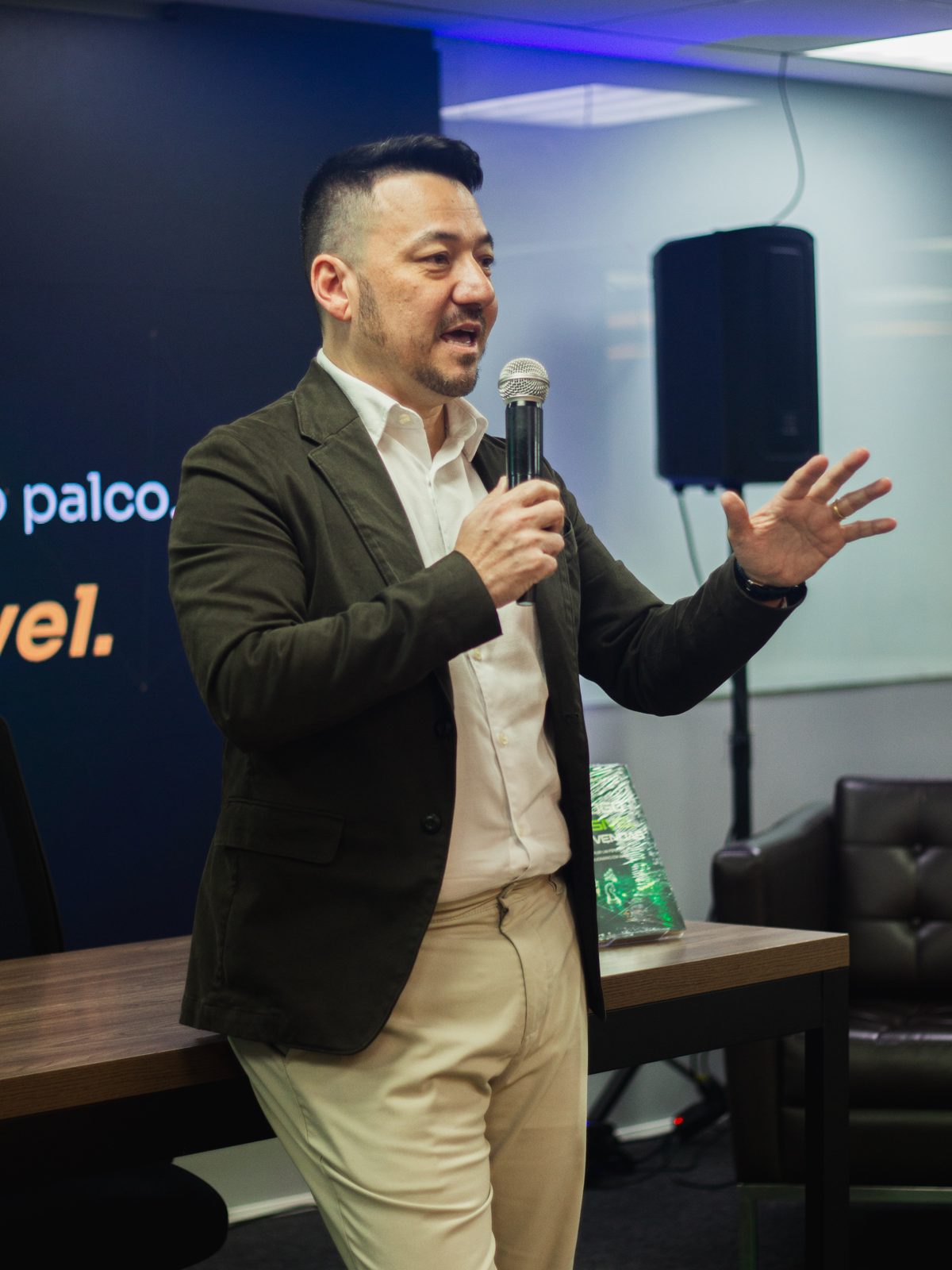 Vinicius Sasaki gesticula enquanto fala ao público no lançamento do livro